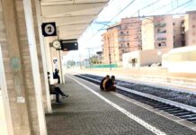 Con i piedi sui binari, follia alla stazione in attesa del treno
